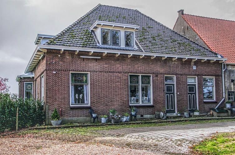 Cottage in Melissant, vacation home in Goeree-Overflakkee with charming brick facade and green surroundings.