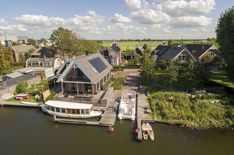 Aerial view of Villa Kaagervaaring, a vacation home in Kaag, Green Heart, South Holland overlooking the water.