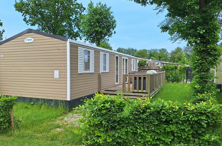 Geniet van de groene omgeving bij EnJoy Natur, See und Meer Chalet Lauwersoog in Groningen met een uitnodigend terras.